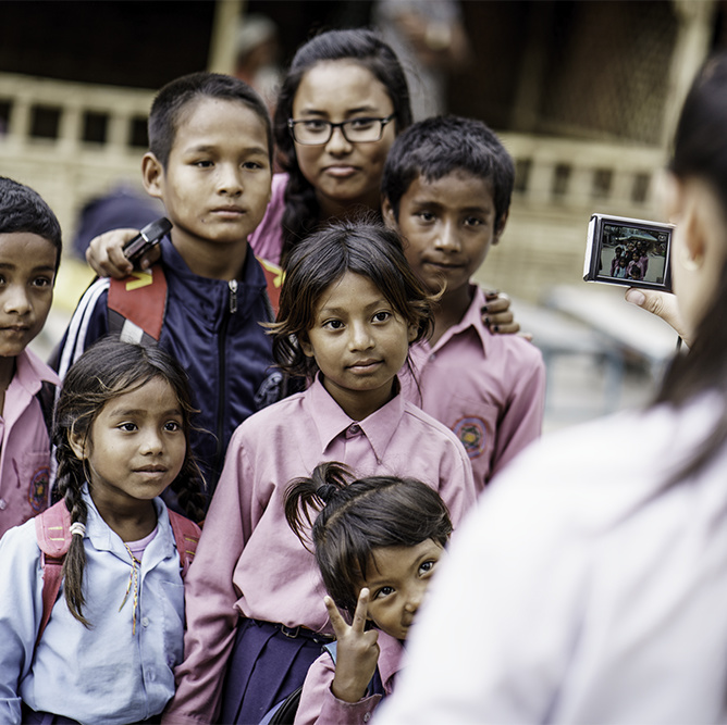 Nuori kuvaa lapsijoukkoa Nepalissa