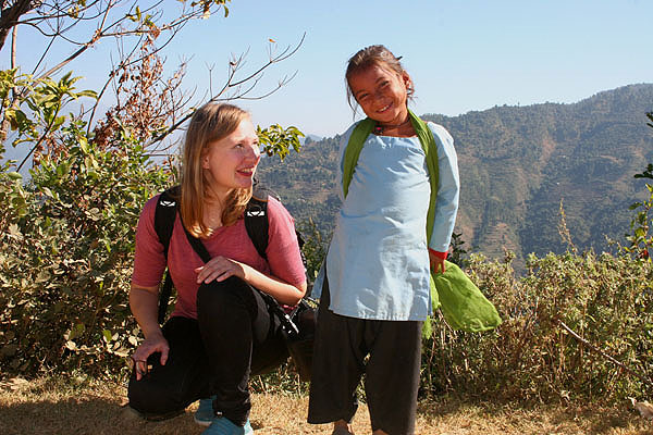 Vapaaehtoistyö Nepalissa: suomalainen vapaaehtoinen pienen nepalilaiskoululaisen vieressä