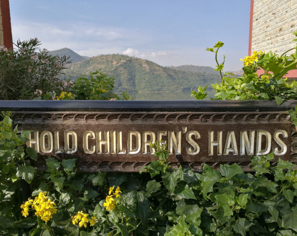 Kyltissä lukee Hold children's hands