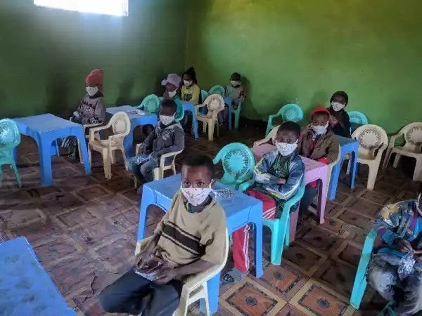 Lapsia maskit päässä päiväkodin oppitunnilla Etiopiassa.