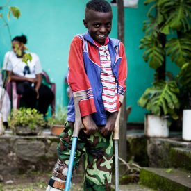 Hymyilevä etiopialainen poika, jolla on kyynärsauvat