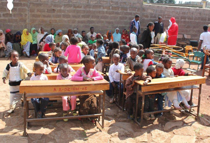 Etiopialaisia lapsia istuu ulkona pulpeteissa