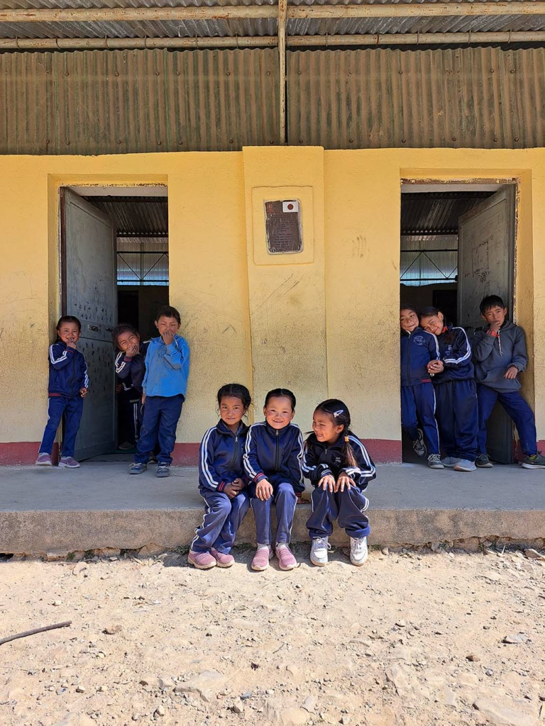 Nepalilaisia koululaisia koulurakennuksen edessä