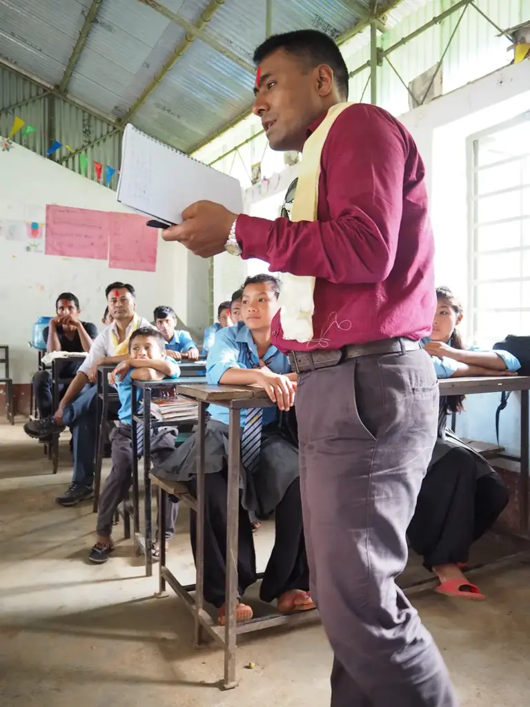 Nepalilainen mies puhuu koululaisille luokassa
