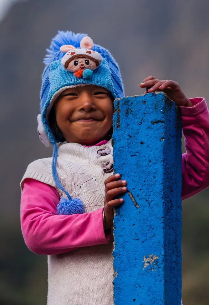 nepalilainen hymyilevä lapsi, jolla on sininen pipo